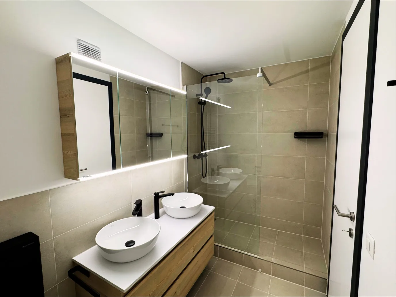 Badezimmer mit Doppellavabo und Walk-in-Dusche nach Umbau in Emmen