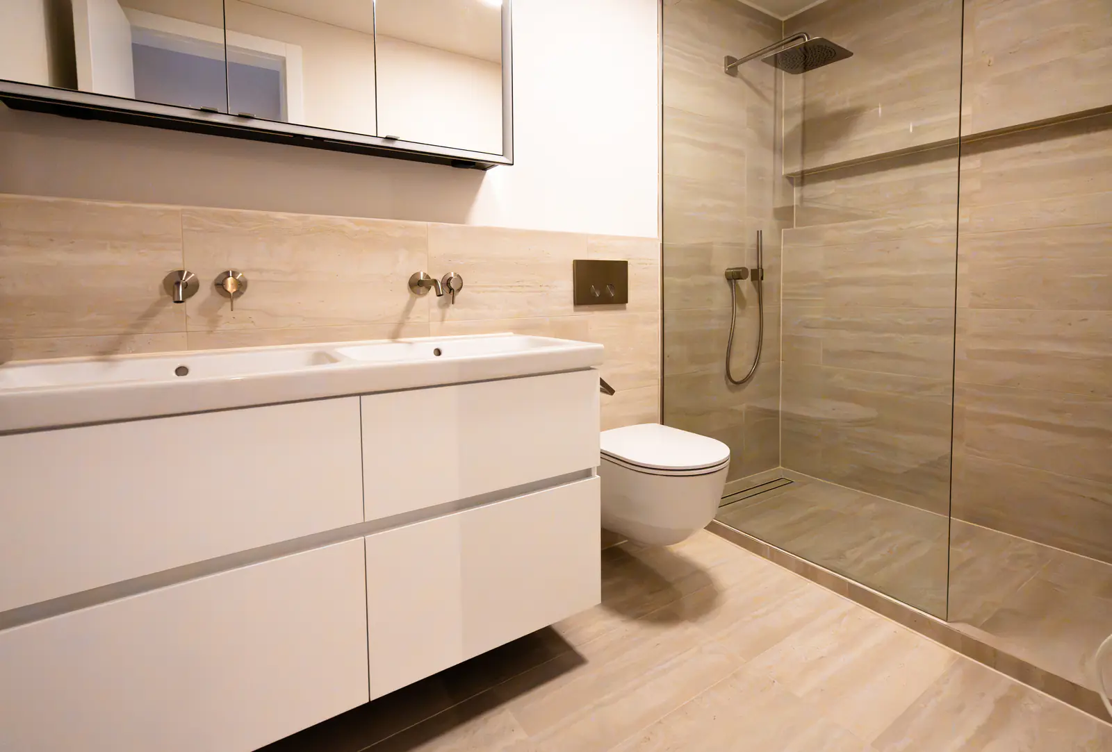 Badezimmer mit Doppellavabo, bodenebener Dusche und Wandplatten in Holzoptik – Umbau in Thalwil
