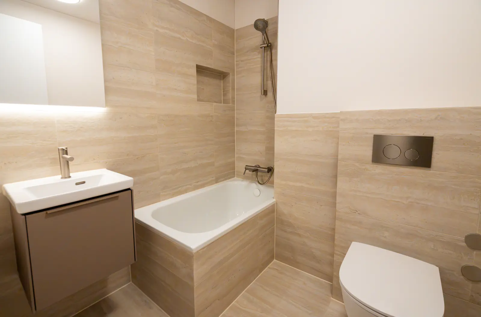 Badezimmer mit Badewanne, Lavabo und Wandplatten in Holzoptik – Umbau in Thalwil