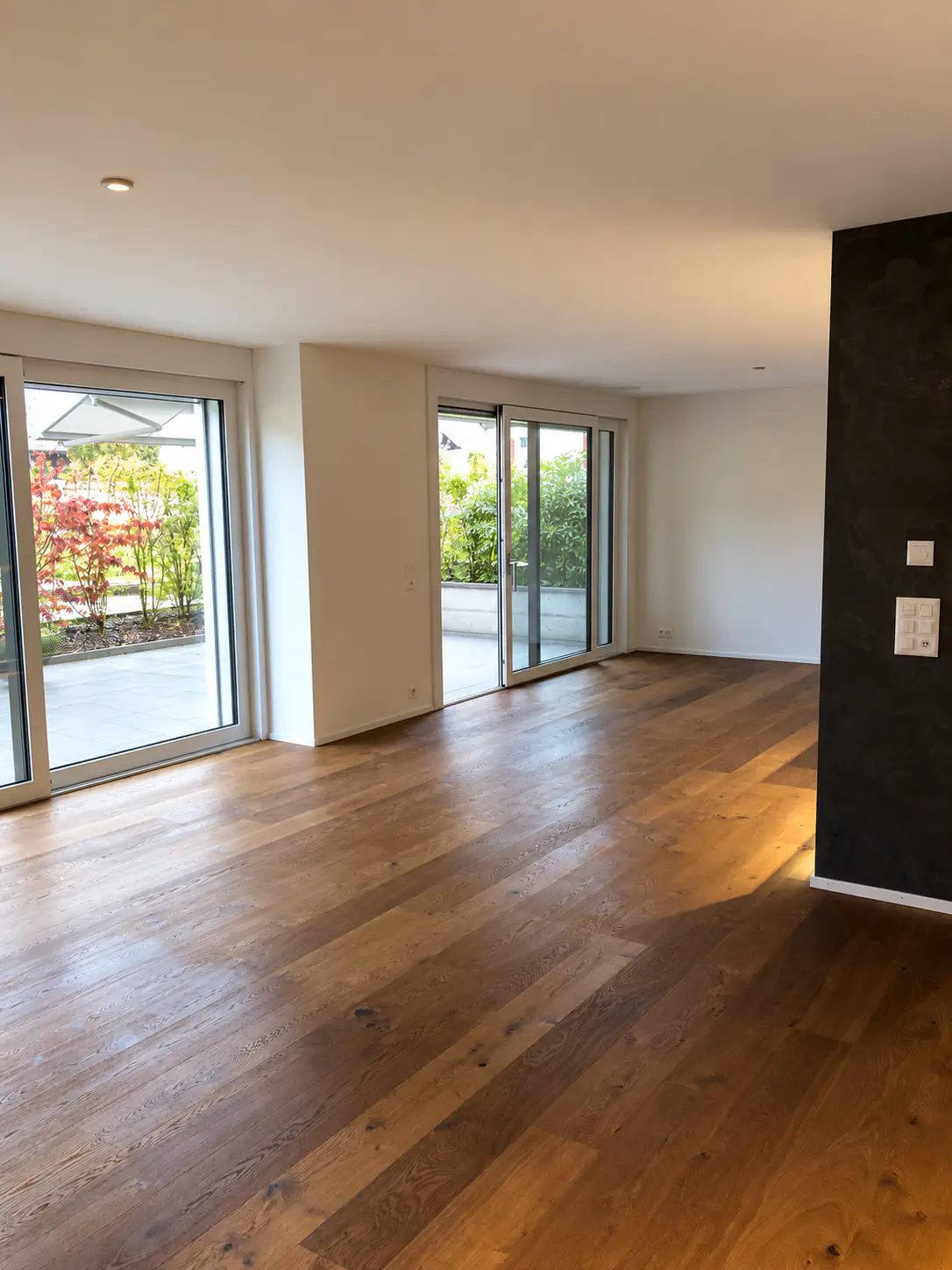 Heller Wohnraum mit Eichenparkett und Terrassenzugang – Neubauwohnung Zürich